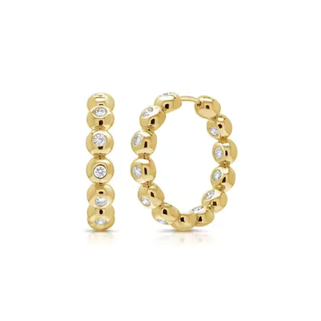 Gold hoop earrings with embedded diamonds on a white background