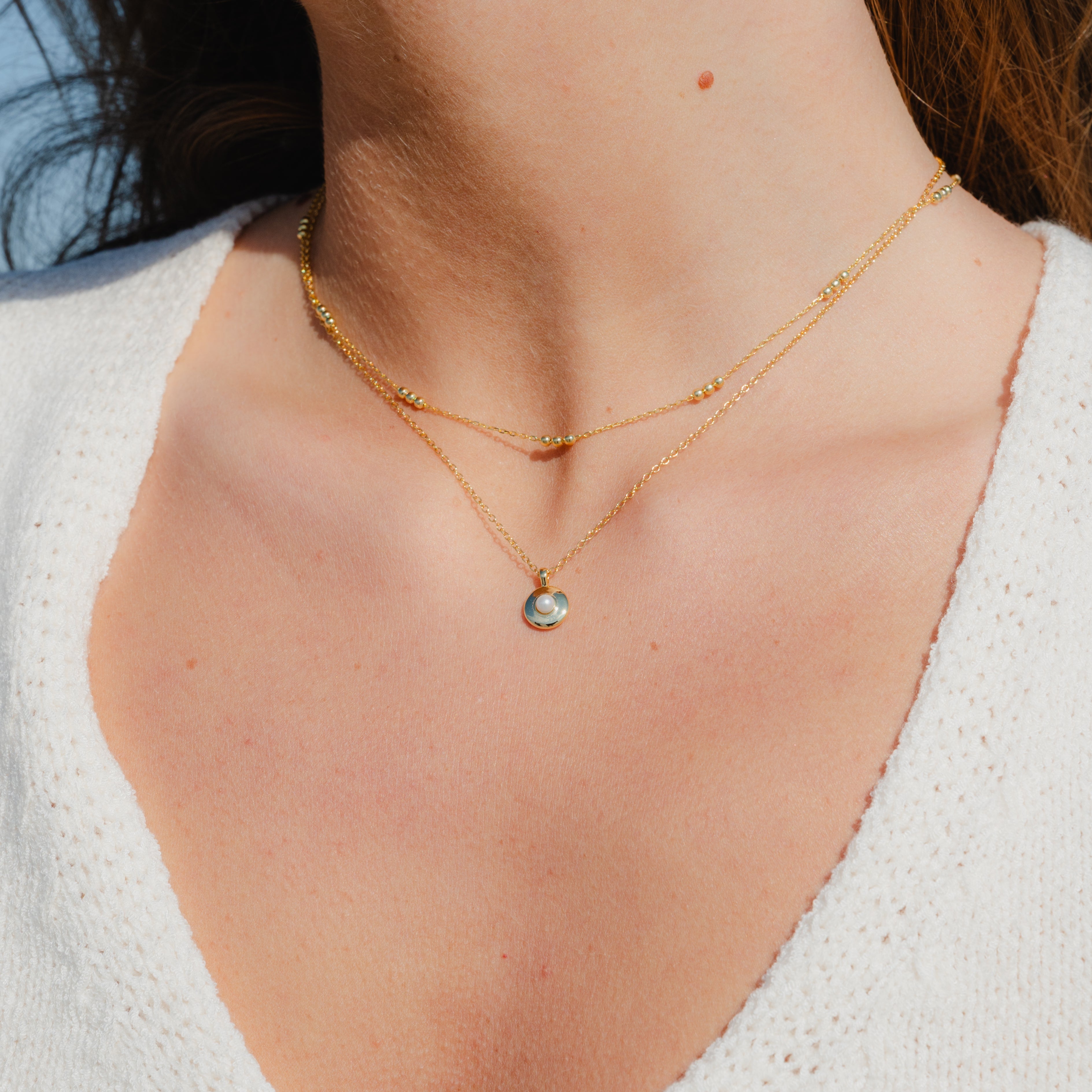 Mini pearl round pendant necklace worn by model, minimalist and elegant