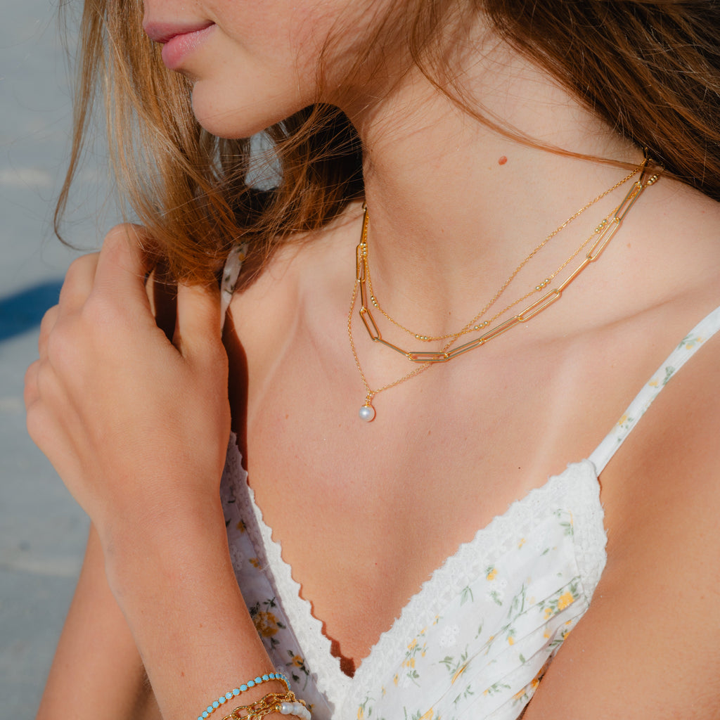 Delicate gold chain necklace with tiny pearl pendant