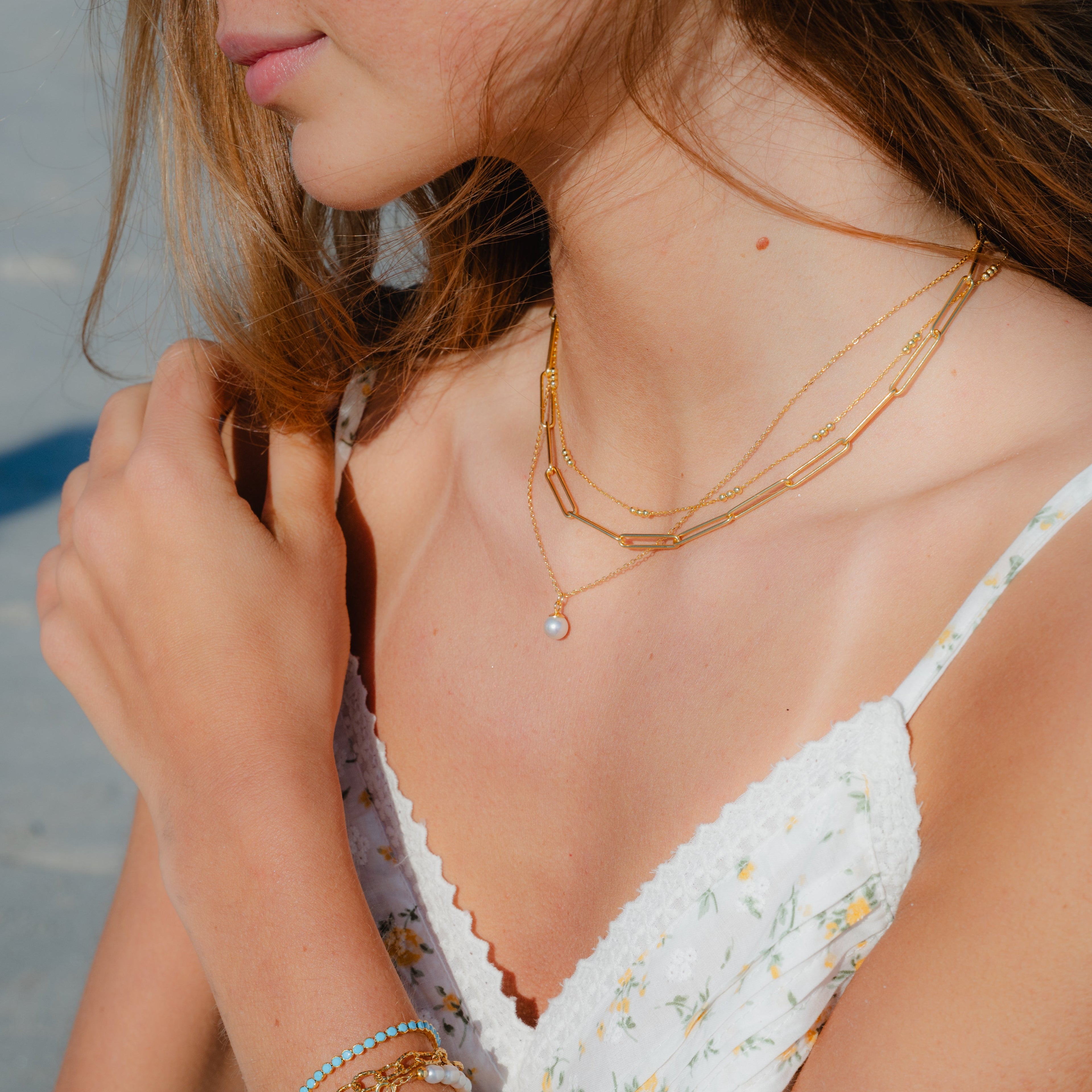 Delicate gold chain necklace with tiny pearl pendant
