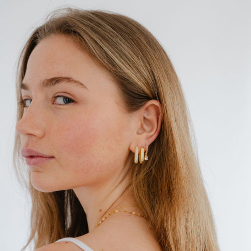 Bold pave gold U hoop earrings worn by model, glamorous and eye-catching