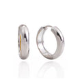 A pair of polished silver hoop earrings shown on a clean white background, with one earring standing upright and the other lying flat to display the side profile.