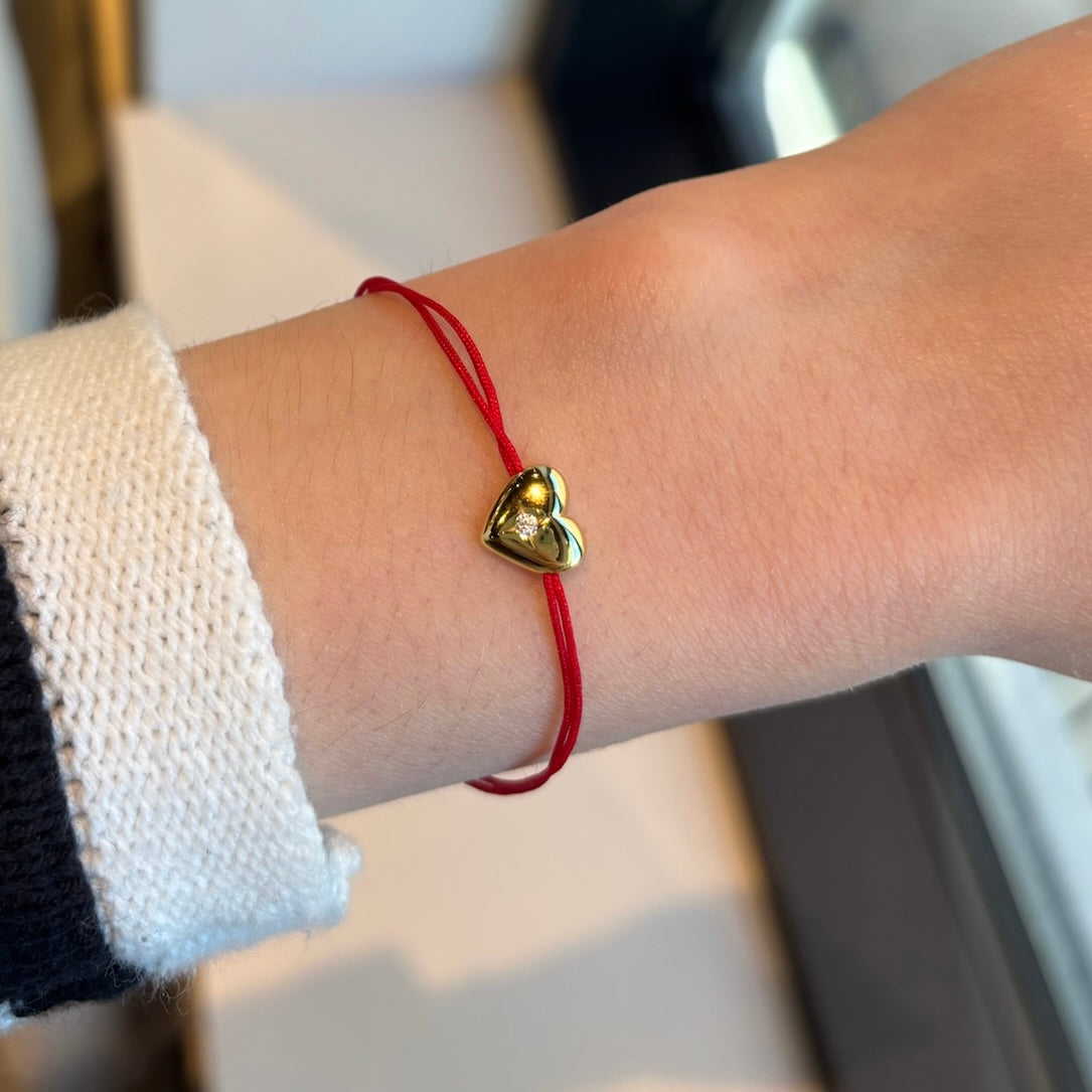 Gold heart red string bracelet worn on wrist, simple and elegant