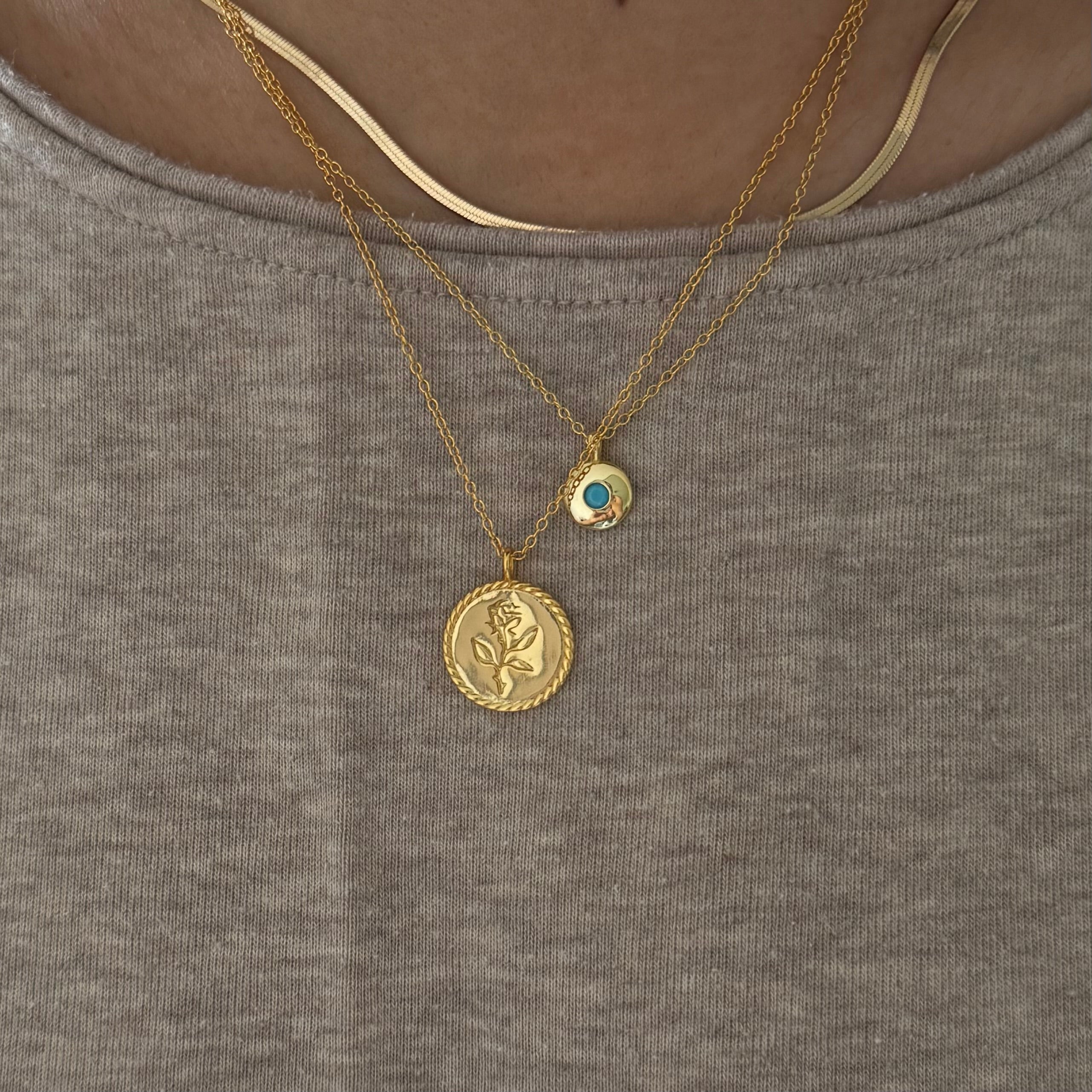 Gold necklace with turquoise pendant styled for a pop of color

