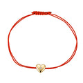 Gold heart charm on red string bracelet, delicate and stylish