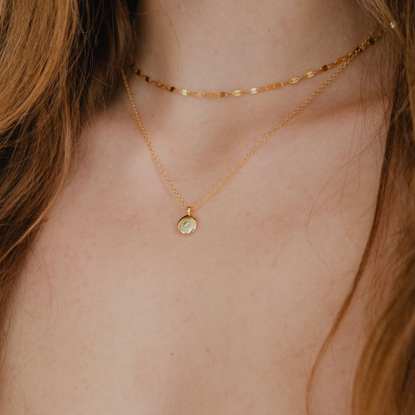 Peridot gold round pendant necklace worn by model, bright and sophisticated

